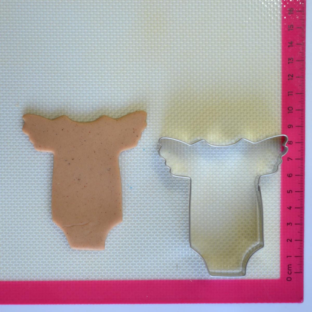 Baby suit cookie cutter with cookie dough cutout 